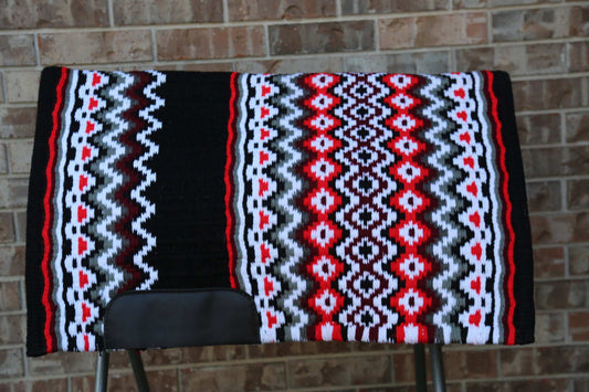 Custom Western Saddle Pad in Red, Brown, White, Black geometric color pattern| Limited Edition displayed on saddle rack with brick background