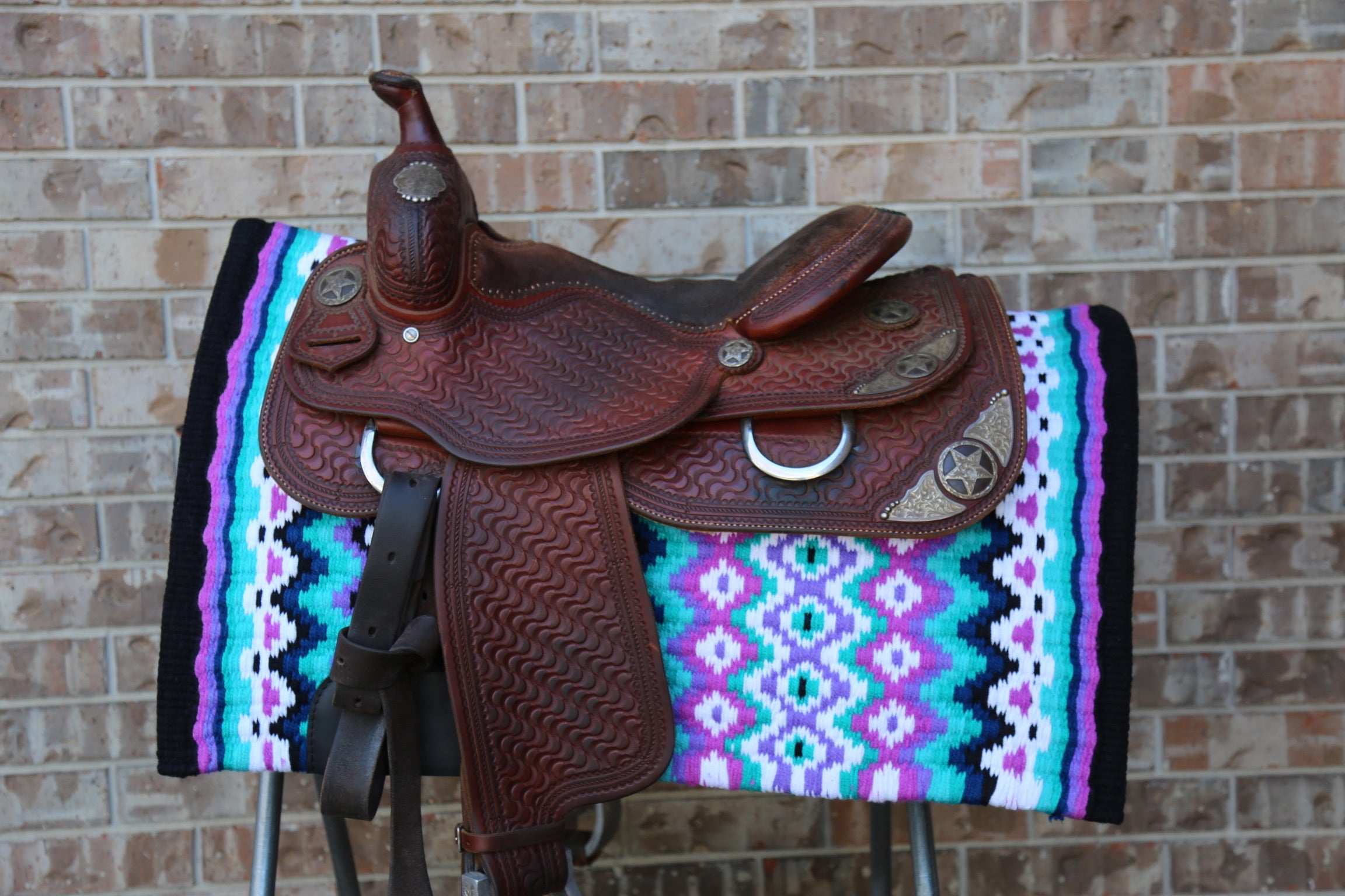 Custom Western Saddle Pad in Blue, Purple, Teal, Black geometric design and colors| Limited Edition displayed on saddle rack with western saddle on top