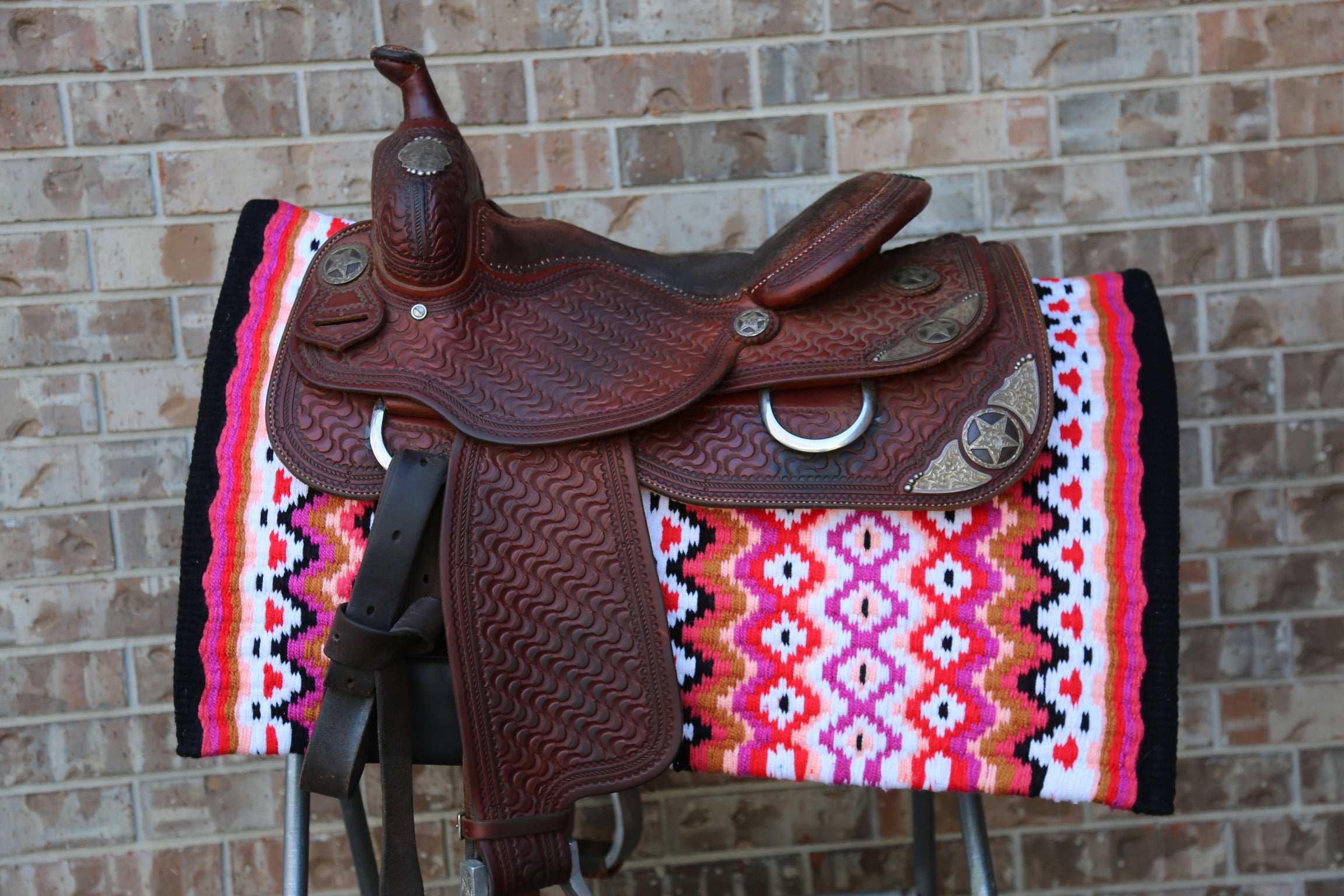 Custom Western Saddle Pad – Pink Hues and Black Details | Limited Edition on a saddle rack with western saddle on top
