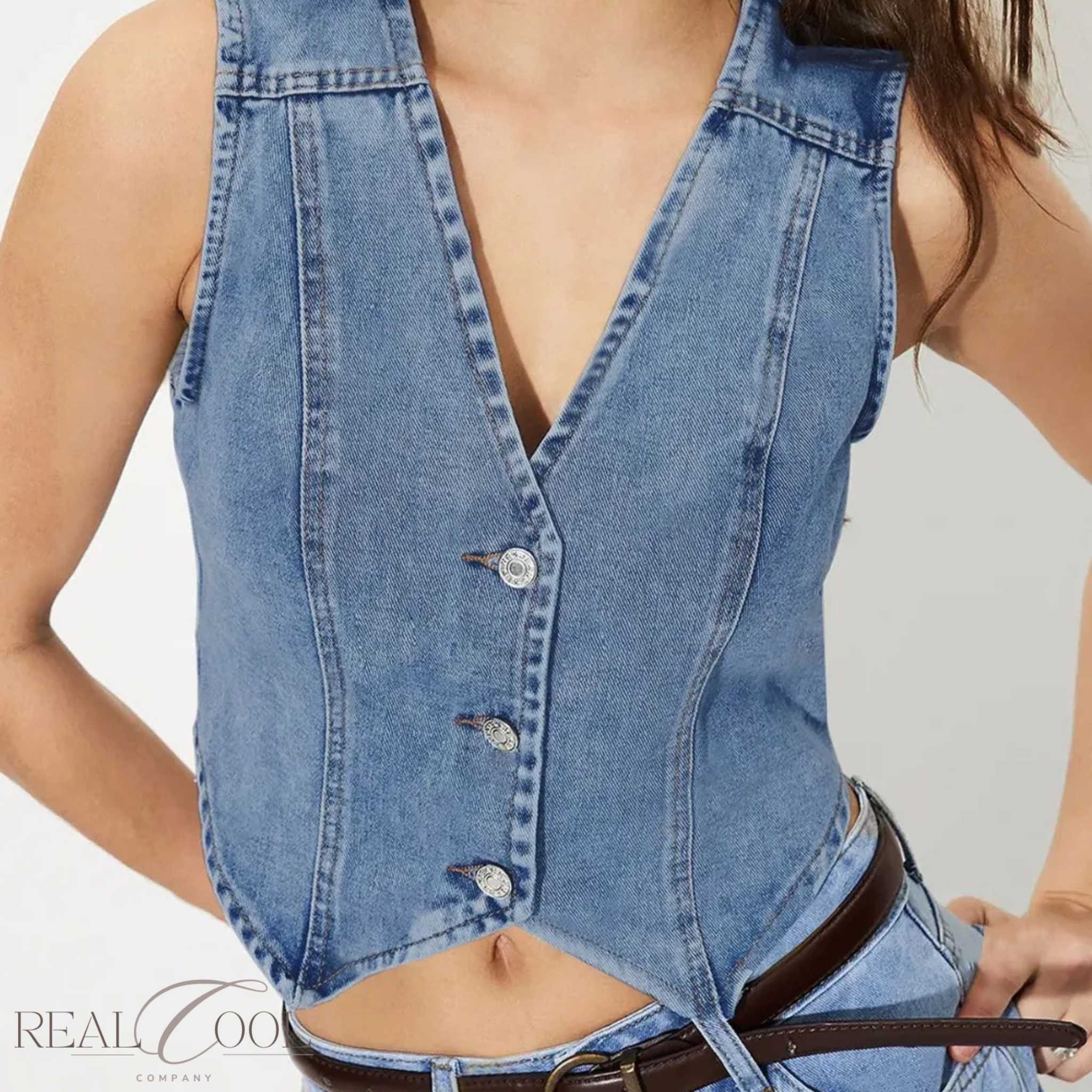 Denim vest worn by a person on a plain background
