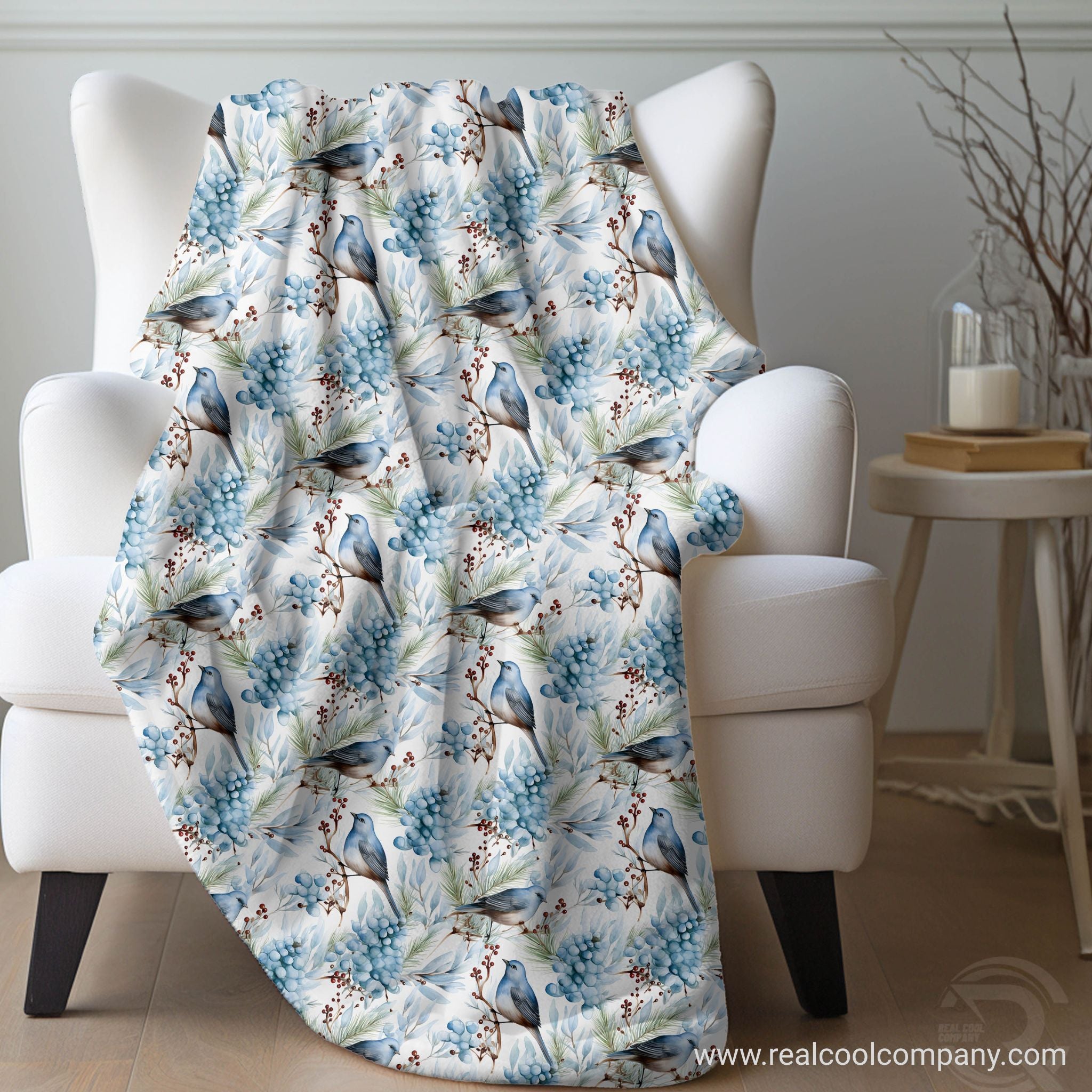 Decorative plush sherpa blanket with watercolor bird and floral pattern draped over a chair next to a side table decor.